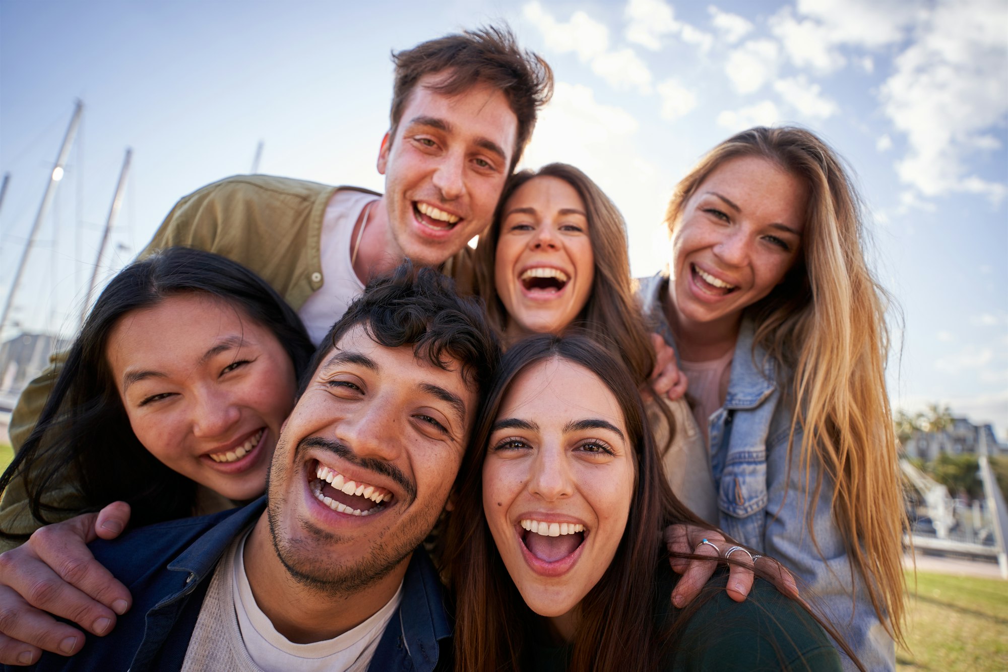 Portrait group diverse young happy people looking excited at camera having fun together outdoor.